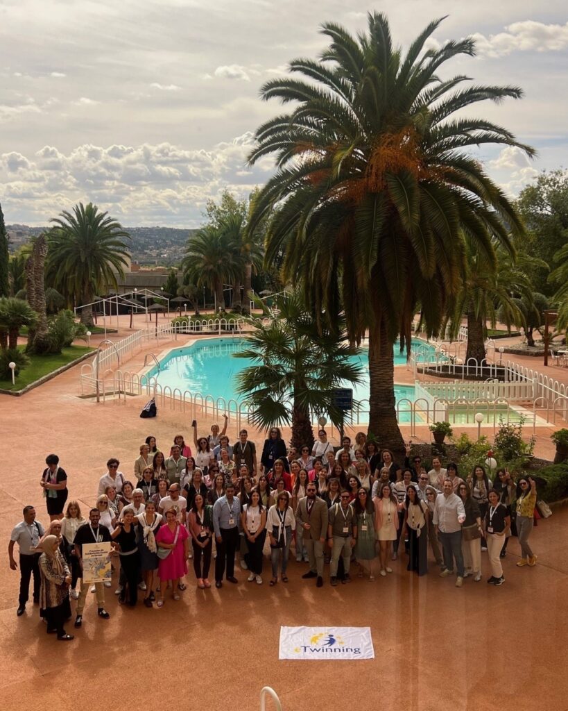 Imagen de grupo en el exterior con cartel eTwinning